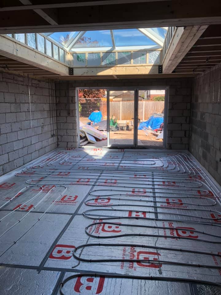 Underfloor heating pipes laid across an extension under construction